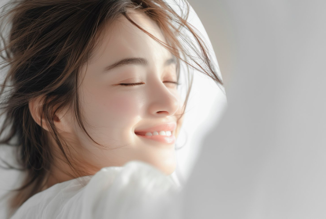 歯を見せて笑っている女性の横顔
